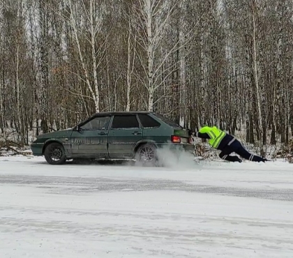 На видео попало, как сотрудник ГИБДД выталкивает из сугроба машину